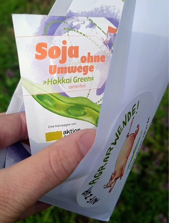 Lass dir unser Soja-Saatgut per Post zuschicken. Eine Person hält Soja-Saatgut im Briefumschlag in den Händen.